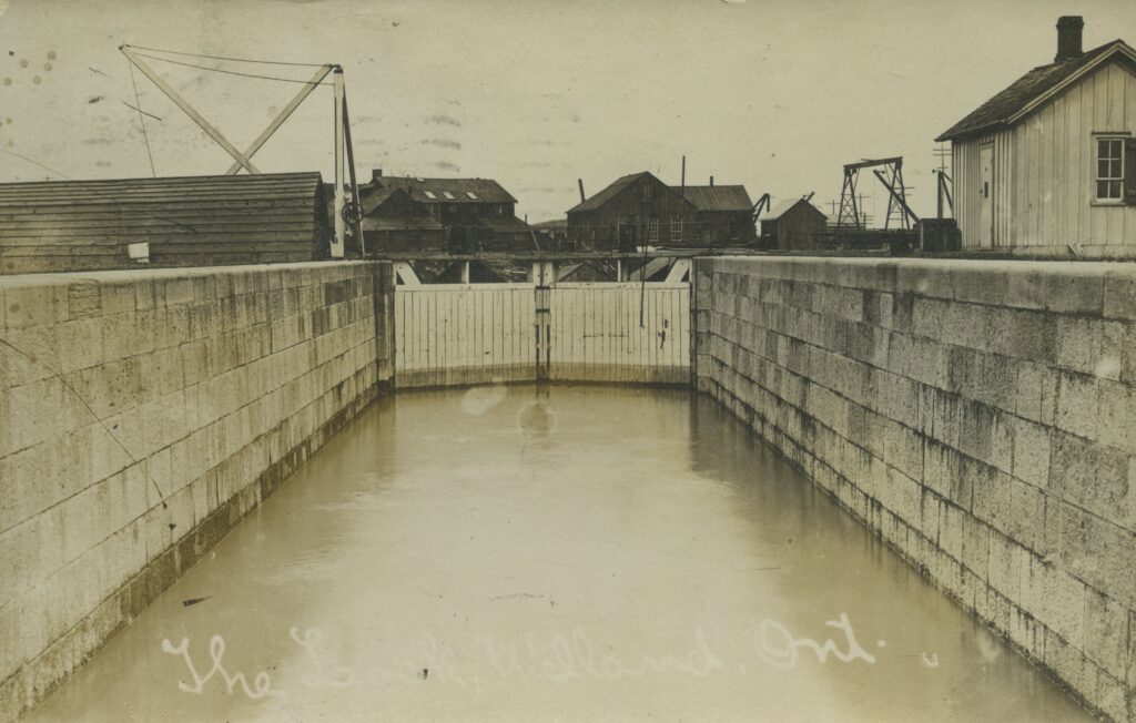 An old photograph showing the canal, and a lock in the canal. 