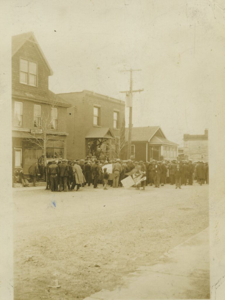 An old photograph of a crowd of people in front of the police station.