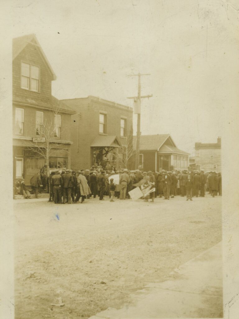 A crowd of people gather outside a building.