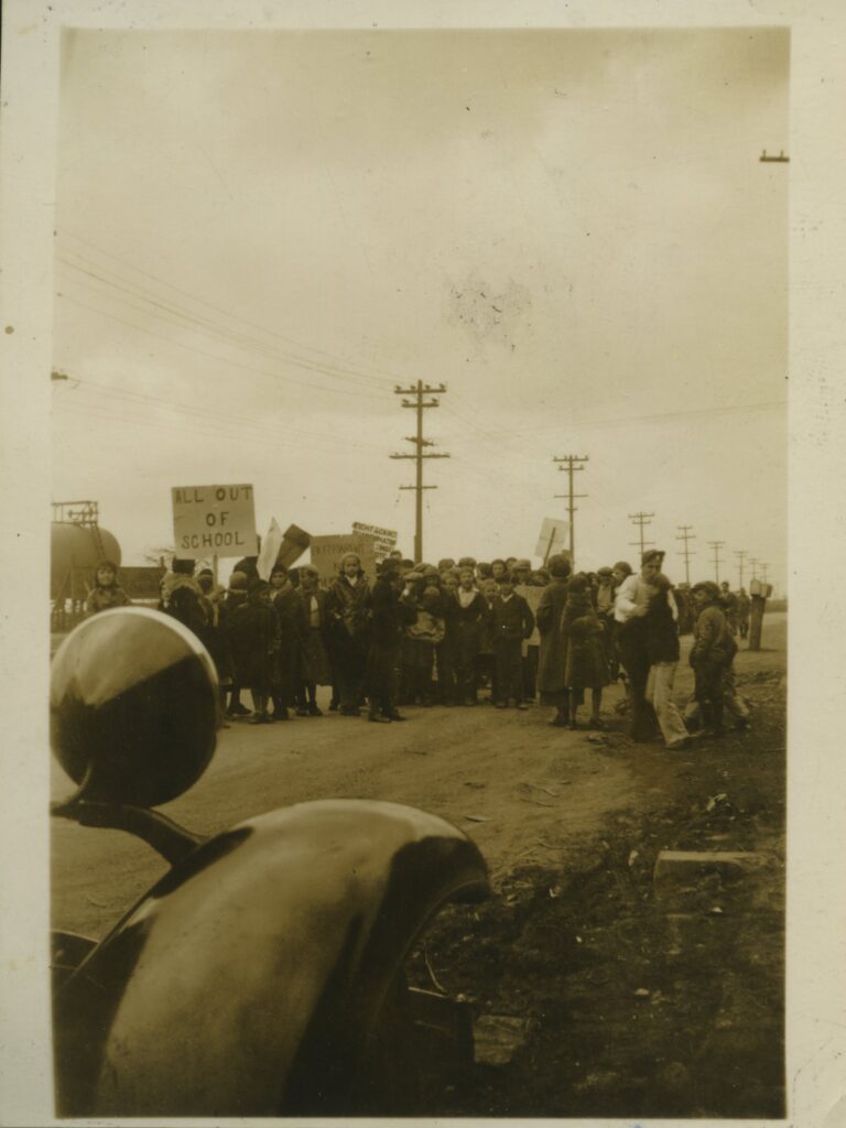 An old photo of a crowd of people holding signs.