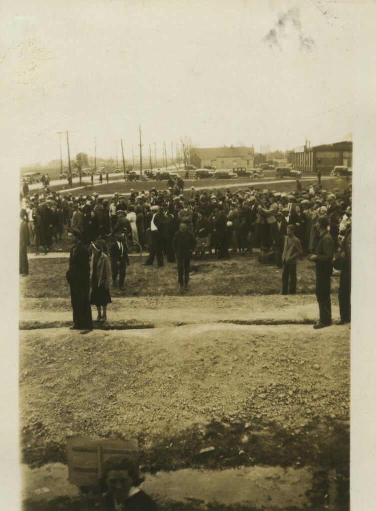 An old photograph of a crowd of people outside.